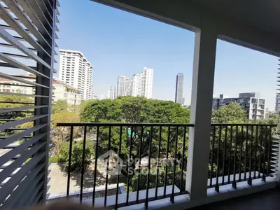 Spacious balcony with stunning city skyline view and lush greenery