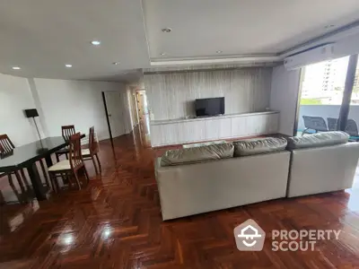 Spacious living room with modern furniture and polished wooden floors in a luxury apartment.