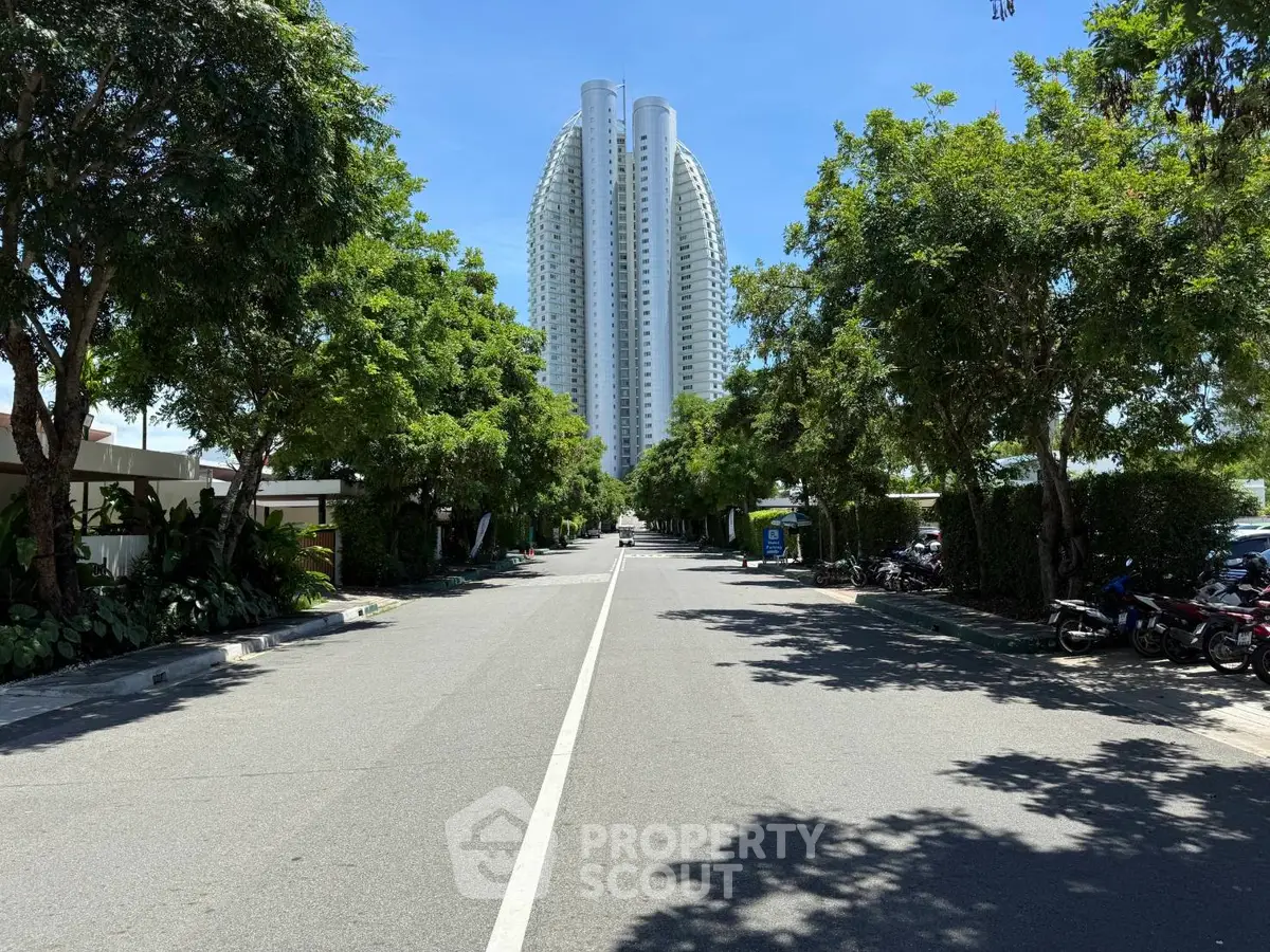 Stunning high-rise building with lush greenery on a sunny day, perfect for modern living.