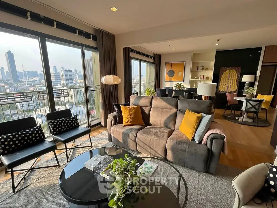 Spacious living room with city view, modern decor, and abundant natural light in a high-rise apartment.