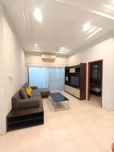 Modern living room with sleek furniture and ambient lighting, featuring a cozy sectional sofa and entertainment unit.