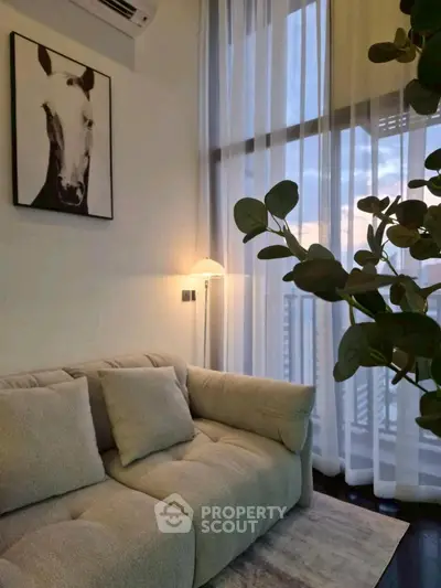Chic living room with plush sofa, modern decor, and floor-to-ceiling windows offering stunning views.