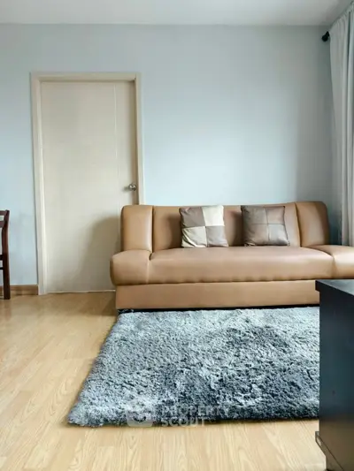 Modern living room with stylish sofa and plush rug in a cozy apartment setting.