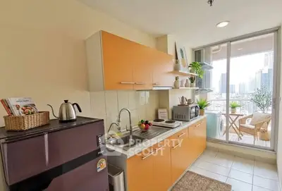 Modern kitchen with orange cabinets and balcony view in high-rise apartment