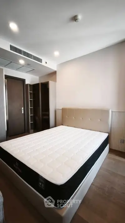 Spacious bedroom with modern design and comfortable mattress in a stylish apartment.