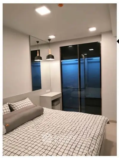 Modern bedroom with stylish lighting and large mirrored wardrobe
