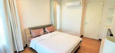 Cozy bedroom with modern decor and natural light, featuring a comfortable bed and air conditioning.