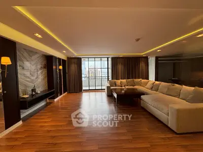 Spacious modern living room with large sectional sofa and city view.