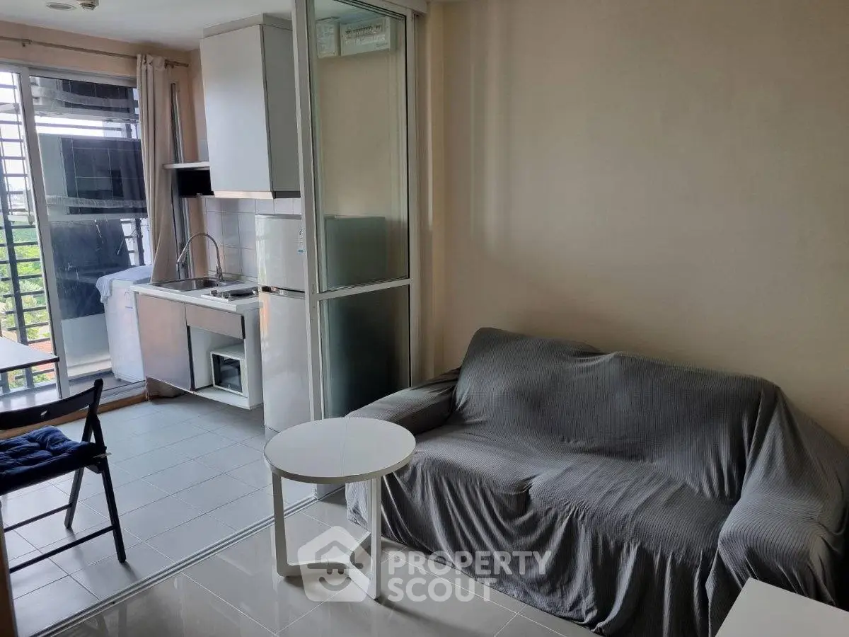 Cozy living room with kitchenette and balcony view in modern apartment