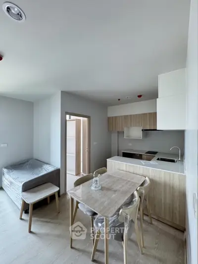 Modern open-plan kitchen and dining area with sleek wooden finishes and natural lighting.