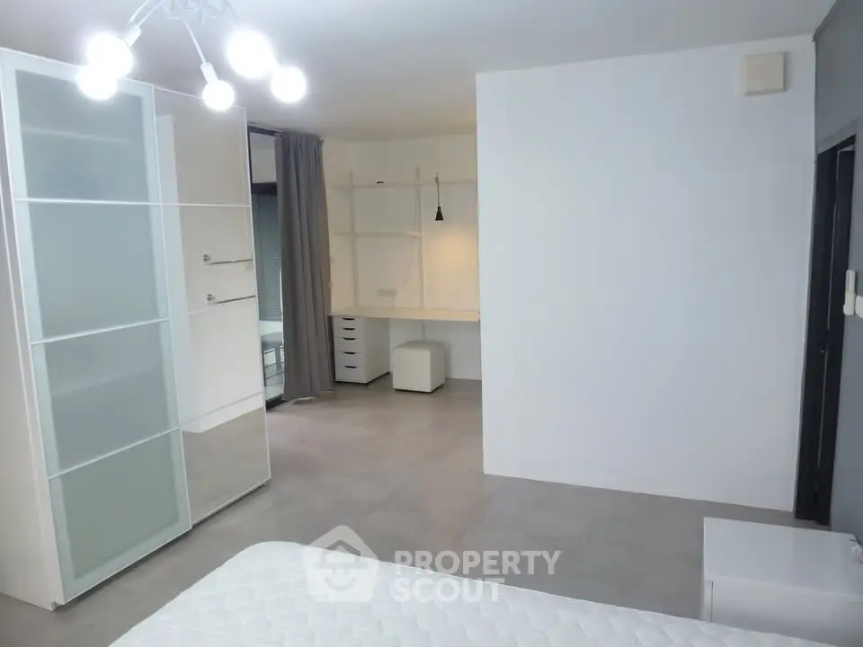 Spacious modern bedroom with sleek wardrobe and study area