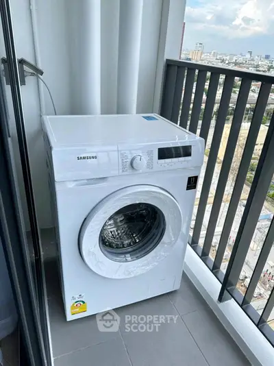 Modern washing machine on a high-rise balcony with city view, perfect for urban living convenience.