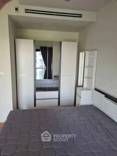 Modern bedroom with sleek wardrobe and comfortable bed in a stylish apartment.