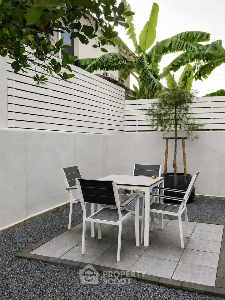 Chic outdoor patio with modern furniture and lush greenery, perfect for relaxation and entertaining.