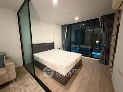 Modern bedroom with glass partition and large window offering natural light