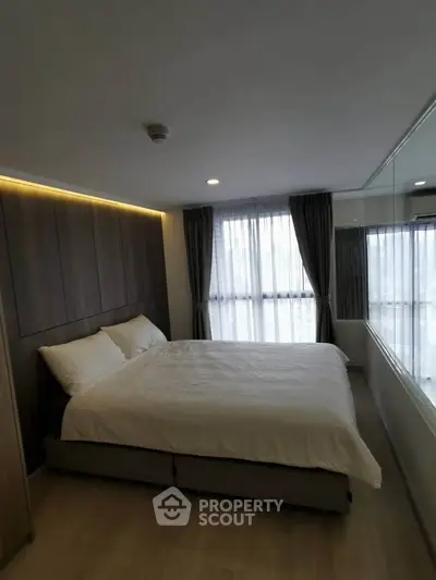 Modern bedroom with large window and elegant decor in a stylish apartment.