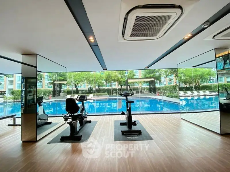 Modern gym with pool view in luxury condominium