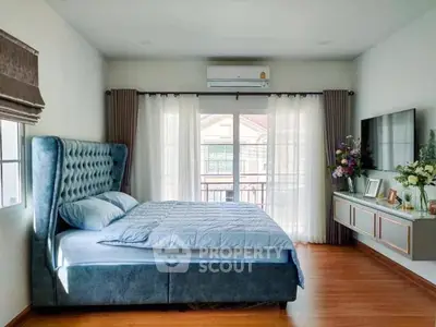 Spacious bedroom with elegant decor and large window view