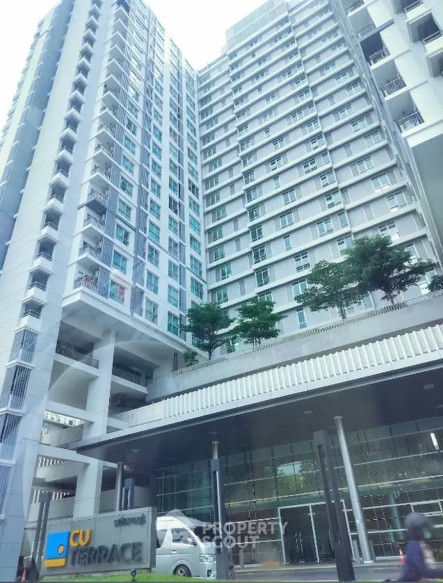 Modern high-rise building with glass facade and lush greenery