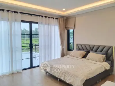 Spacious bedroom with large windows and balcony access, offering serene views and natural light.