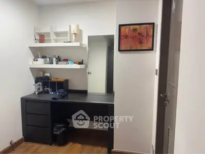 Modern study room with sleek black desk and wall shelves, perfect for productivity.
