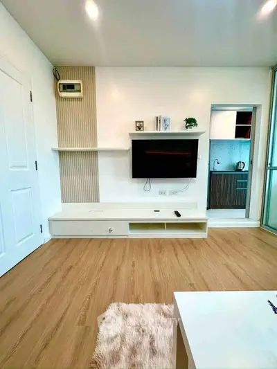 Modern living room with wall-mounted TV and open kitchen layout