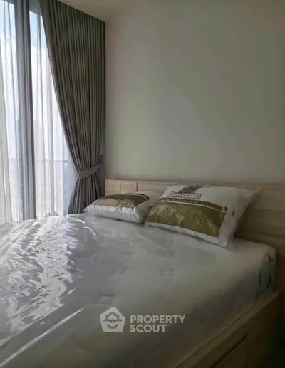 Cozy bedroom with large window and elegant curtains, perfect for relaxation and comfort.