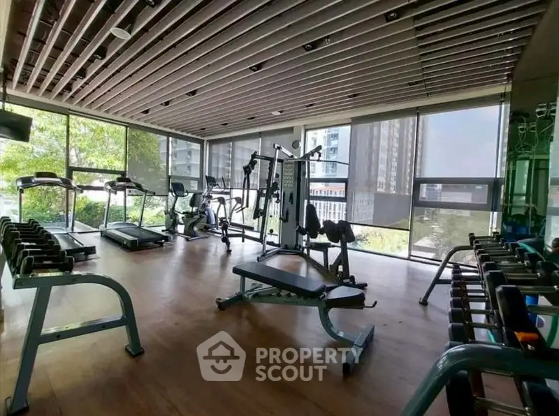 Modern gym with state-of-the-art equipment and large windows offering a scenic view.