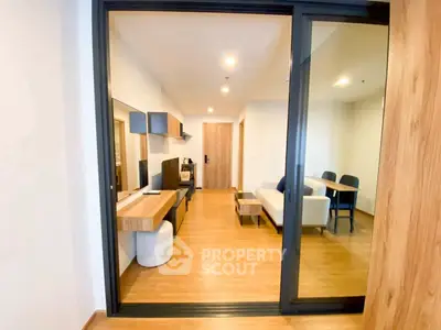 Modern living room with sleek design and wooden flooring, featuring a cozy seating area and stylish decor.