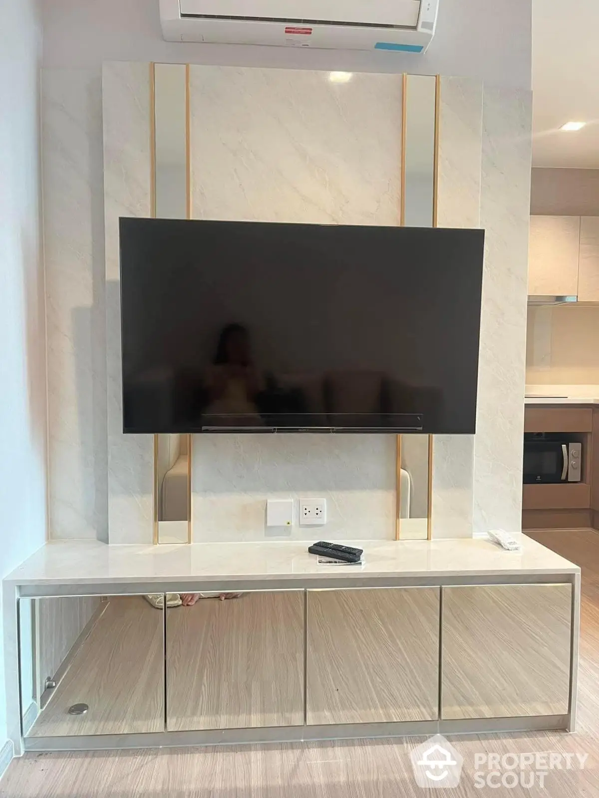 Modern living room with sleek TV setup and mirrored cabinet