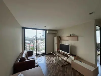 Modern living room with city view, featuring sleek furniture and large window for natural light.