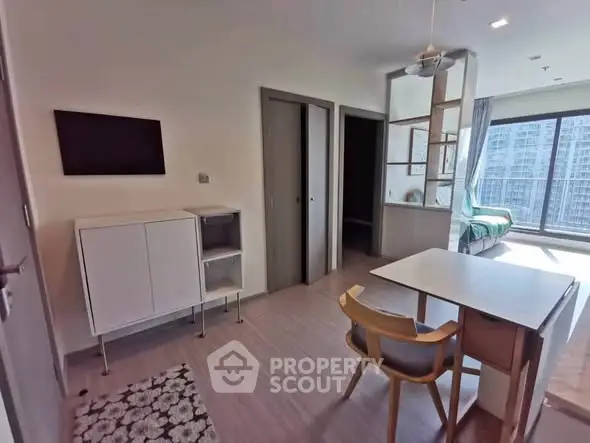 Modern apartment interior with open layout and large windows offering city views.