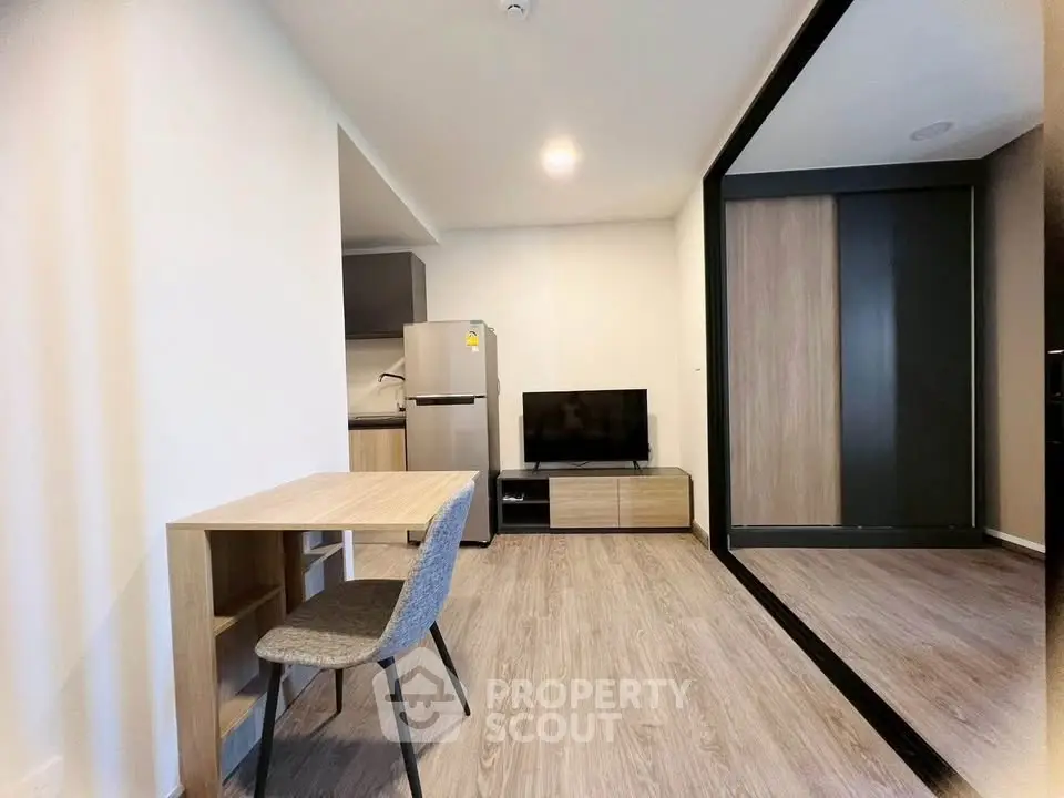 Modern apartment interior with sleek kitchen and cozy living area, featuring stylish furniture and contemporary design.