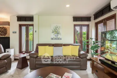 Spacious living room with modern decor and large windows offering garden views.