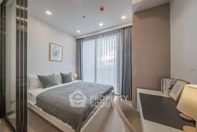 Modern bedroom with cozy decor and large window offering natural light.