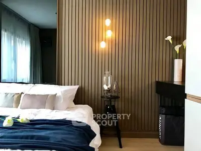 Modern bedroom with stylish lighting and cozy decor, featuring a comfortable bed and elegant wooden paneling.