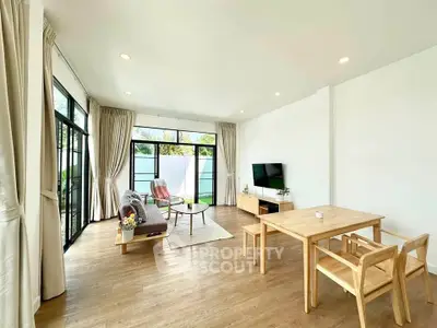 Spacious modern living room with large windows and elegant wooden furniture