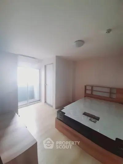 Spacious bedroom with natural light and modern furnishings, ideal for comfortable living.