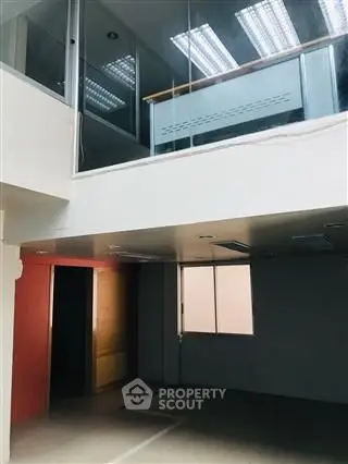 Spacious modern interior with high ceilings and large windows in a commercial space.