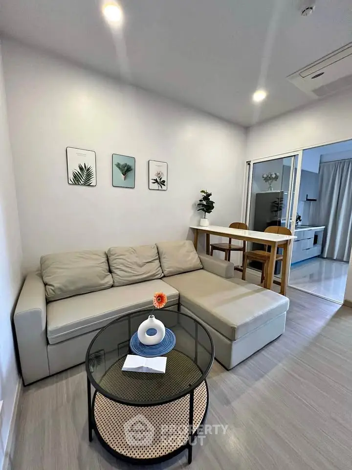 Modern living room with cozy sectional sofa and stylish decor in open-plan apartment.