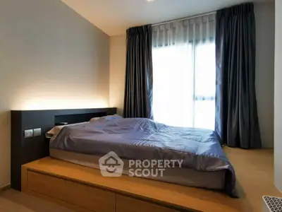 Modern bedroom with sleek design and natural light from large window.