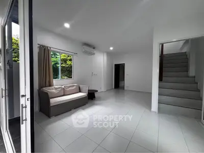 Spacious modern living room with sleek staircase and natural light