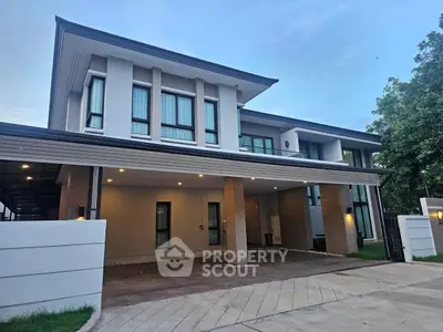 Modern two-story house with spacious driveway and sleek architectural design.