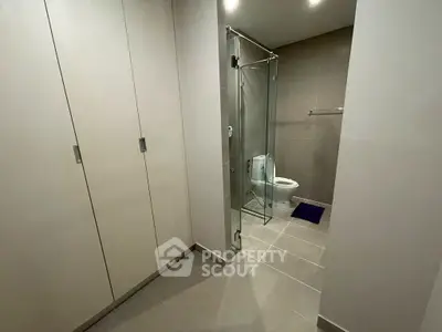 Modern bathroom with glass shower and sleek storage cabinets