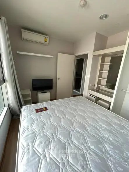 Cozy bedroom with air conditioning and natural light, featuring a comfortable bed and modern decor.