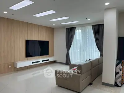Spacious modern living room with sleek design and large TV setup