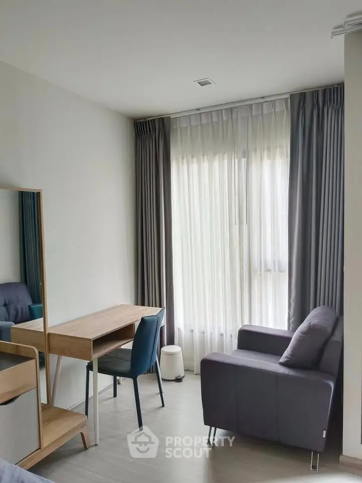 Modern living room with cozy armchair and stylish desk near large window