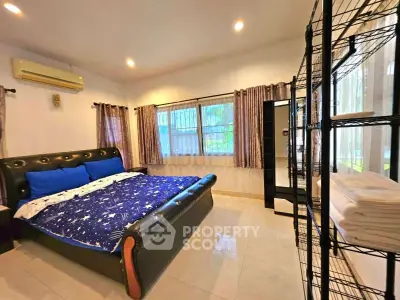Spacious bedroom with modern decor and large windows for natural light.