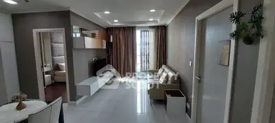 Modern living room with sleek design and natural light, featuring a cozy sofa and stylish TV unit.