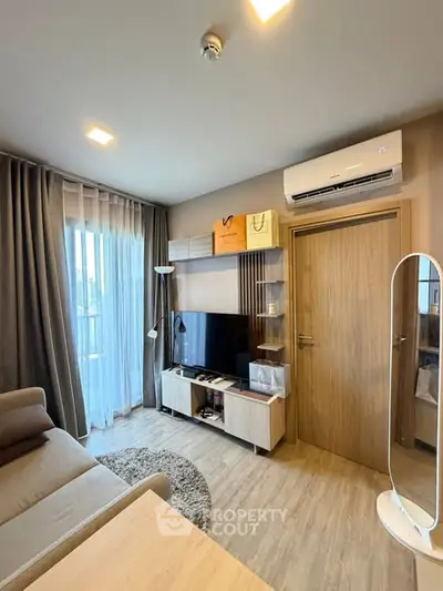 Modern living room with sleek furniture and natural light, featuring a cozy sofa and entertainment center.